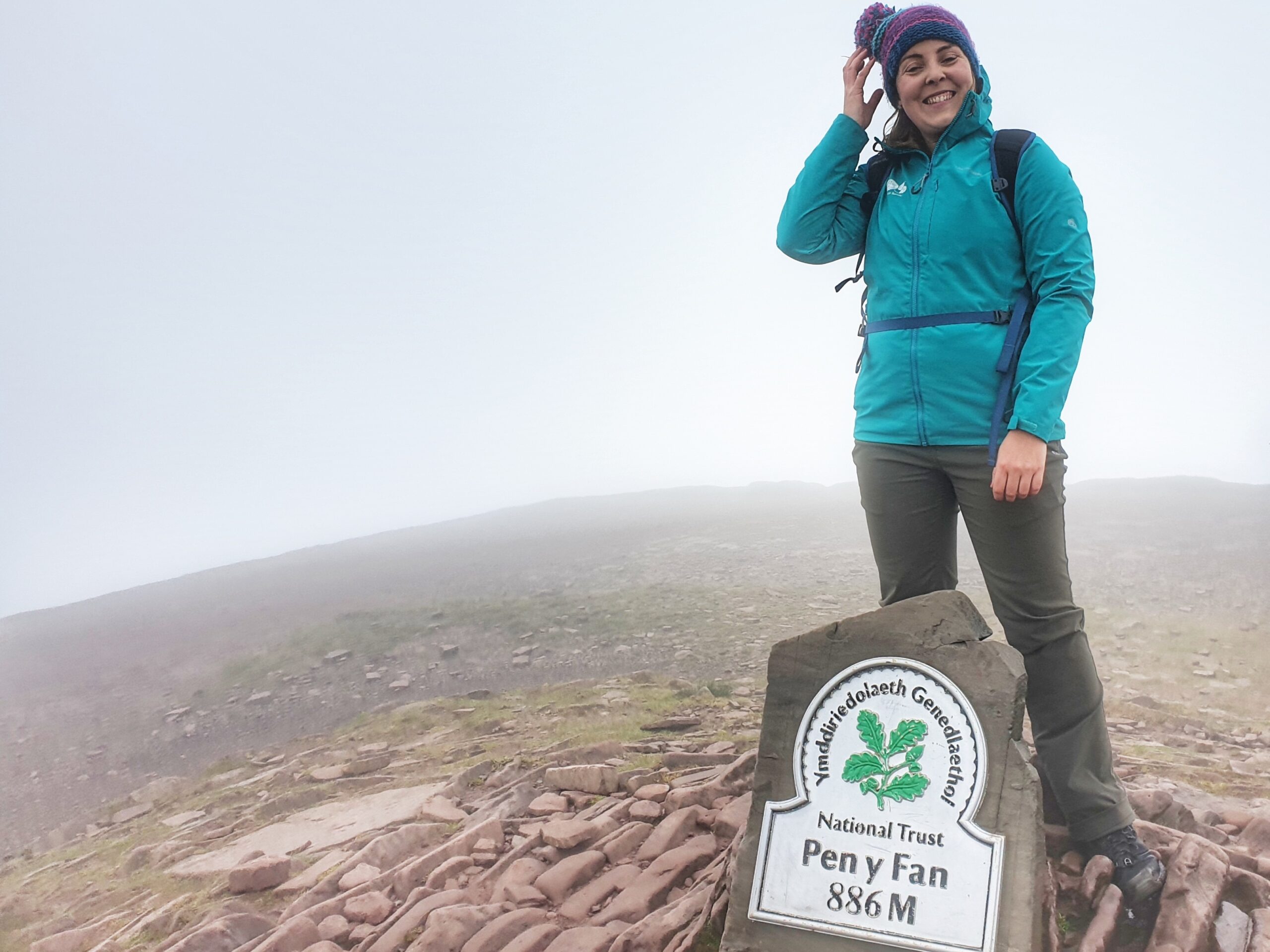 Woman in green coat at top of Pen Y Fan