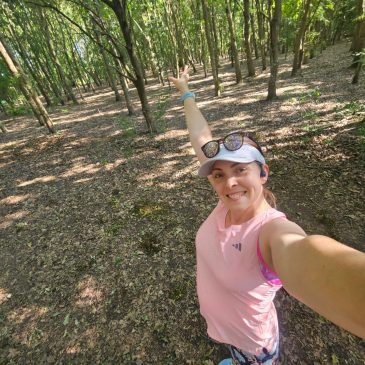 Woman in pink tank top standing in the woods