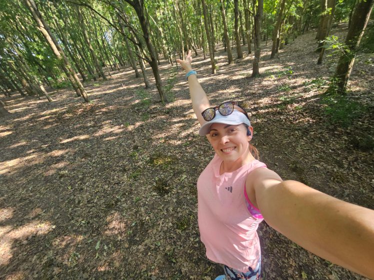 Woman in pink tank top standing in the woods