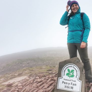 Woman in green coat at top of Pen Y Fan